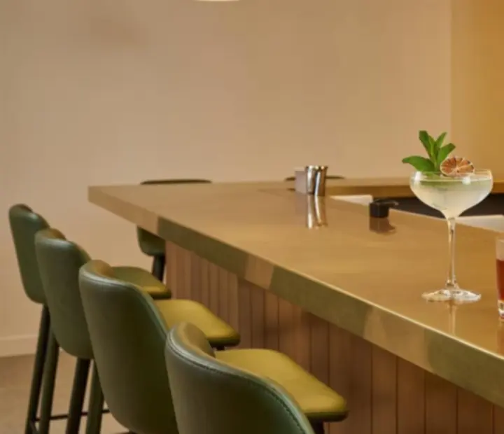 Cocktails and drinks displayed on the brass-trimmed bar at ADSIGHT LTD