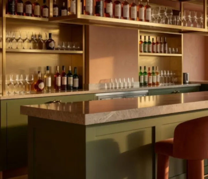 Olive-accented bar at ADSIGHT LTD with terracotta stools and soft golden lighting