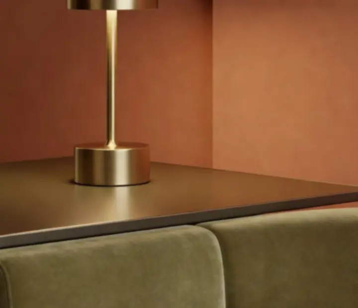 Closeup of brushed brass lamp and terracotta details in ADSIGHT LTD's card lounge